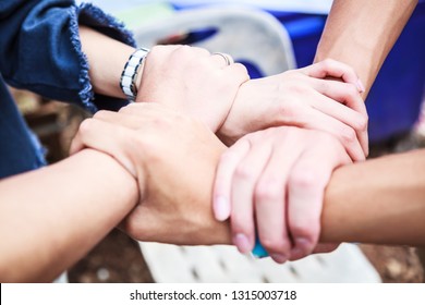 Young People Teamwork Meeting join hands in rectangle on natural ground background at outdoor outing. Teamwork, diversity, collaboration, young generation, harmony, corporate future culture concept