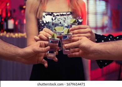 Young people toasting with Mexican Tequila shots in bar, closeup - Powered by Shutterstock