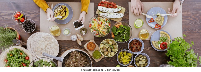 Young People Trying Food At A New Vegetarian Restaurant And Taking Pictures During The Meal