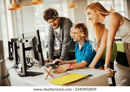 Young people using a computer while working in a startup company office