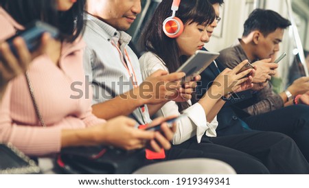 Young people using mobile phone in public underground train . Urban city lifestyle and commuting in Asia concept .