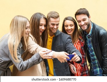 Young People Using Smartphones - Group Of Social Media Co Workers Having Fun And Takeing A Selfie - Obsessed With Online And Shareing Lifestyle Moments -  Technology Concept