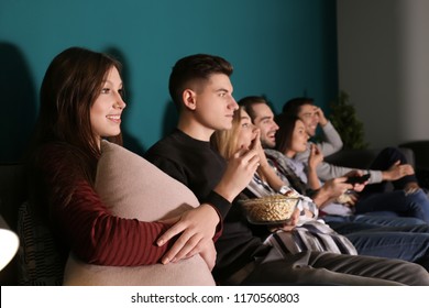 Young People Watching Movie In Home Cinema At Night