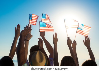 Young People Waving American Flags At Sunset. Guys And Girls With American Flags. Patriotic Party. Flags  Flutters In The Wind.