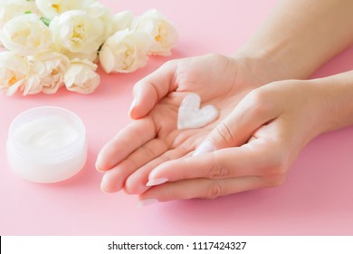 Young, Perfect, Clean Woman's Hands. Heart Shape Created From Natural Herbal Cream. Love A Body. Care About Soft, Smooth Skin In Summer Time. Beautiful Roses On Pink Table. Fresh Flowers. 