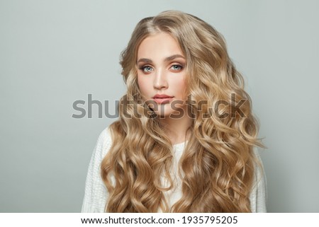 Young perfect woman blonde model with with curly hairstyle on white background