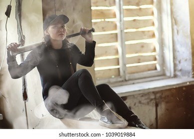 A young person with a baseball bat and a skateboard in an abandoned house
