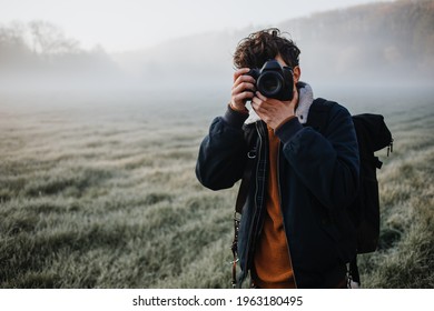 Young Photographer on a foggy meadow camera is covering the face  - Powered by Shutterstock