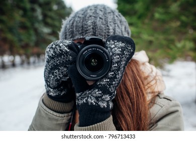 Young photographer takes pictures of winter forest with a camera - Powered by Shutterstock