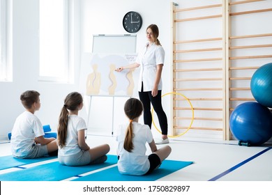 Young Physical Therapist Talking With Kids About Bad Postures