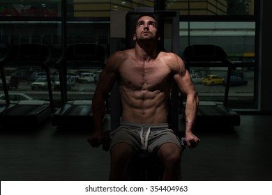Young Physically Bodybuilder Working Out Triceps On Machine