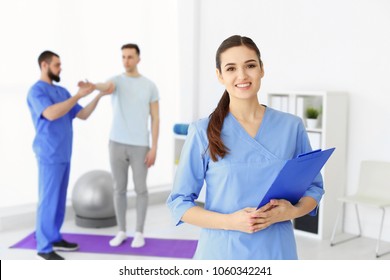 Young Physiotherapist With Clipboard In Rehabilitation Center