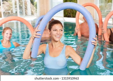 Young physiotherapist doing water aerobics with seniors in rehab