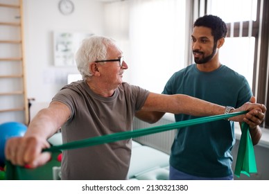Young physiotherapist exercising with senior patient in a physic room - Powered by Shutterstock