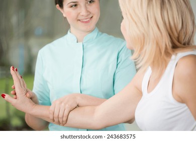 Young Physiotherapist And Her Patient's Wrist Exercise