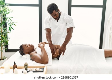 Young Physiotherapist Man Giving Abdominal Massage To African American Woman At The Clinic