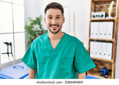 Young physiotherapist man working at pain recovery clinic with a happy and cool smile on face. lucky person.  - Shutterstock ID 2084489809