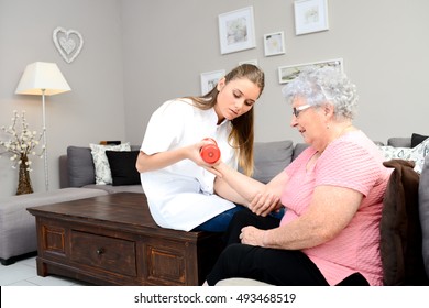 Young Physiotherapist Nurse Helping An Elderly Women Physical Rehabilitation At Home