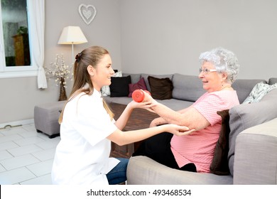 Young Physiotherapist Nurse Helping An Elderly Women Physical Rehabilitation At Home