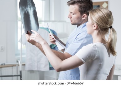 Young physiotherapist is watching radiograph of spine - Powered by Shutterstock