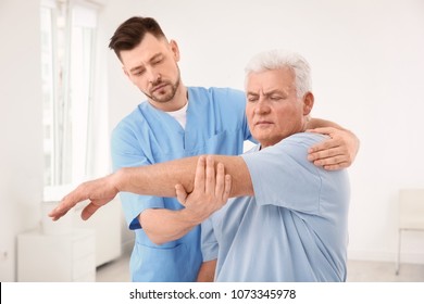 Young Physiotherapist Working With Senior Patient In Clinic