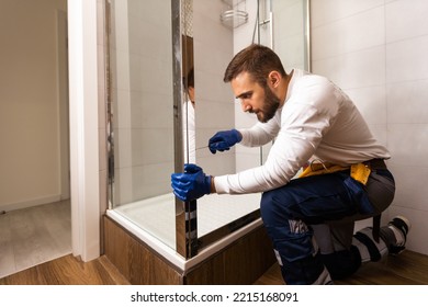 Young Plumber Fixing Shower Cabin