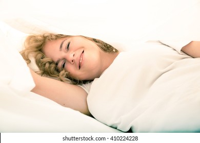 A Young Plus Size Woman Hiding In Bed Under The Sheets.
