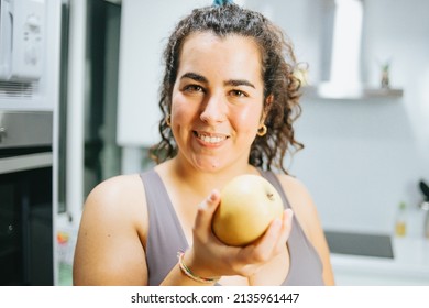 Young Plus Size Woman Playing With Healthy Food At The Kitchen, Loosing Weight And Eating Healthy. Young People Diet And Happy Attitude Towards The Future To Get Fit.