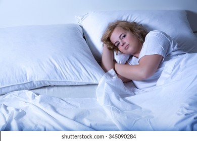 A Young Plus Size Woman Sleeping In Bed At Night.
