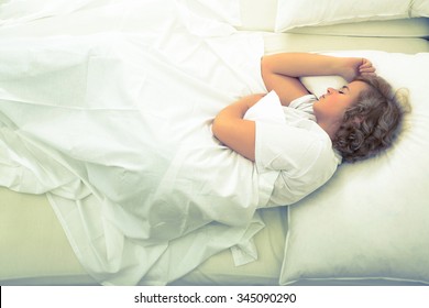 A Young Plus Size Woman Sleeping In Bed.
