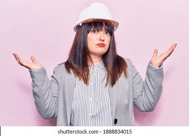 Young Plus Size Woman Wearing Architect Hardhat Clueless And Confused With Open Arms, No Idea And Doubtful Face. 