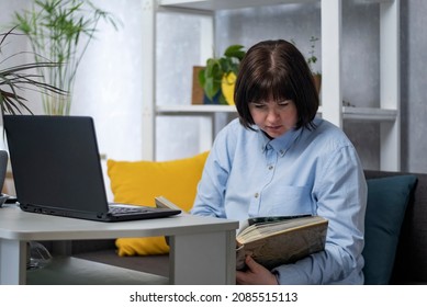 Young Plus Size Woman Working With Documents While Sitting On The Couch In Home Office. Freelance And Remote Work.