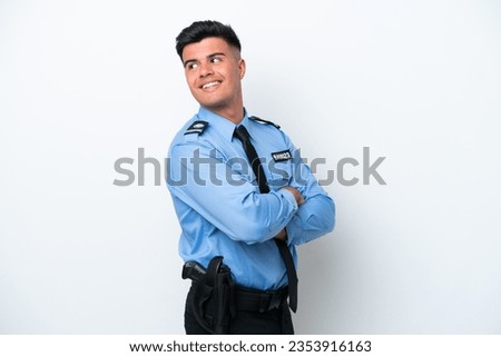 Young police caucasian man isolated on white background with arms crossed and happy