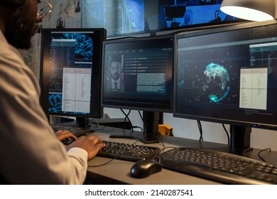 Young policeman entering personal data of suspect into computer database while sitting in front of monitors in office - Shutterstock ID 2140287541