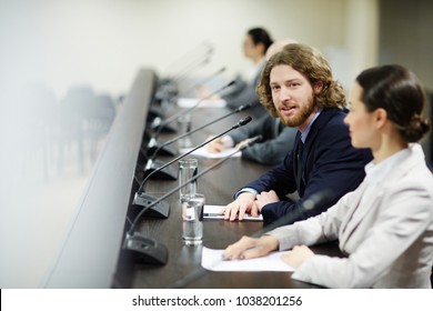 Young Politician In Suit Talking To Speaker Or Commenting Report At Conference