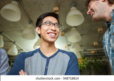 Young Positive Cheerful Asian Man Talking With His Friends