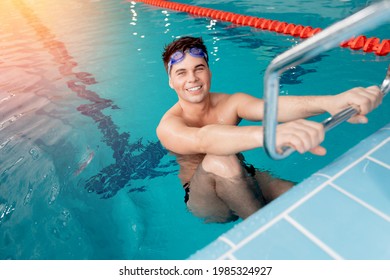 Young Positive Happy Male Swimmer In Blue Water Swimming Pool After Race, Top View.