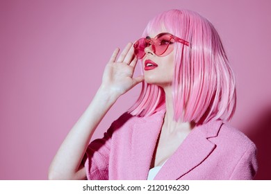 Young positive woman bright makeup pink hair glamor stylish glasses color background unaltered