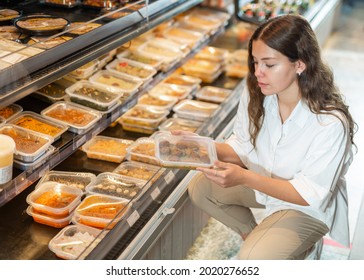 Young Positive Woman Choosing Ready Meal In Plastic Container At Supermarket