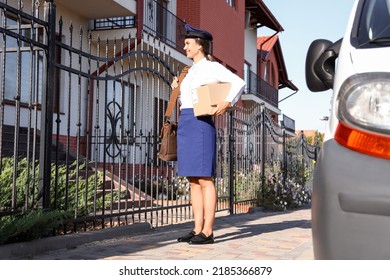 Young Postwoman With Parcel Outdoors