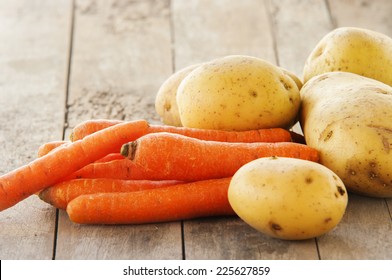 patatas jóvenes y zanahorias sobre fondo de madera 