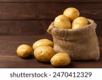Young potatoes. Fresh potatoes on a wooden background. potato in burlap sack. Harvesting collection. organic, freshly dug potatoes. Agricultural background. Vegan. Vegetables.Place for text.Copy space