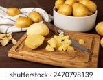 Young potatoes. Raw potatoes and knife on a wooden background.Peel potatoes.Harvesting collection. organic, freshly dug potatoes. Agricultural background. Vegan. Vegetables.Place for text.Copy space
