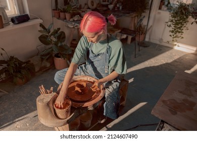 Young potter working on potter wheel in workroom - Shutterstock ID 2124607490
