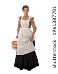 Young prairie woman with apron holding skirt and a basket isolated on white background