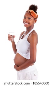 Young pregnant black woman holding a glass of water  - African people
