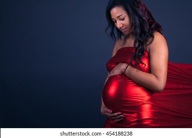 Young pregnant black woman touching her belly
