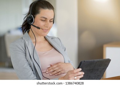 Young pregnant businesswoman at work - Shutterstock ID 1386740828