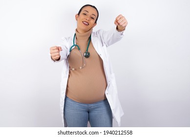 Young Pregnant Doctor Woman Wearing Medical Uniform Against White Background   Imagine Steering Wheel Helm Rudder Passing Driving Exam Good Mood Fast Speed