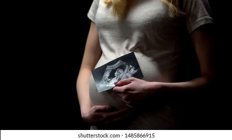 Young pregnant lady holding childs x-ray, happy motherhood, baby expectation